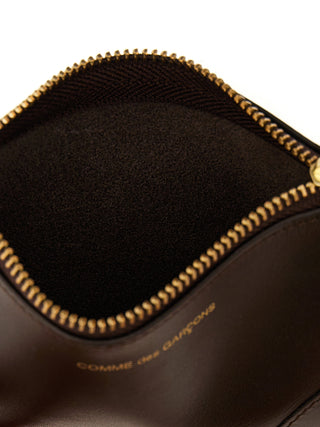 Brown calfskin cardholder by Comme Des Garçons with multiple card slots and sleek minimalist design.