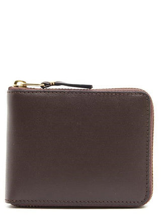 Brown cowhide leather wallet by Comme Des Garçons showing textured surface and compact design.