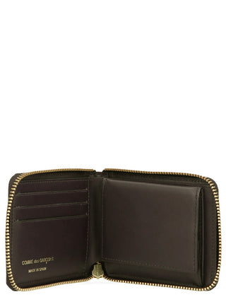 Brown cowhide leather wallet by Comme Des Garçons with multiple card slots and a sleek, minimalist design.