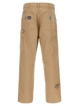 Beige organic cotton casual pants by Carhartt Wip, relaxed fit with front pockets and adjustable waistband.