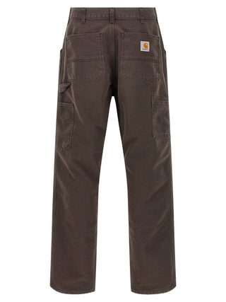 Carhartt Wip brown organic cotton casual pants with relaxed fit and functional design, shown on a model.