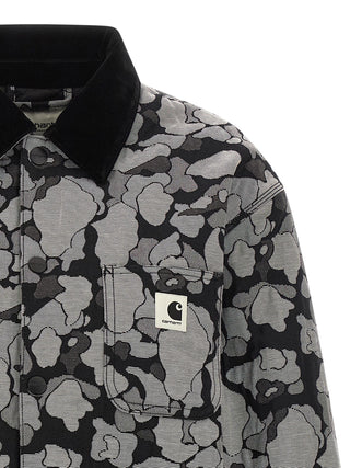 Gray Carhartt Wip cotton full-length jacket with front pockets and a hood, displayed on a hanger.