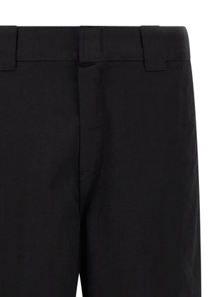 Carhartt Wip black polyester casual pants with a relaxed fit and functional design, shown on a model.