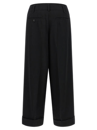 Black wool cropped pants by Comme Des Garçons, featuring a tailored fit and modern design, shown on a mannequin.