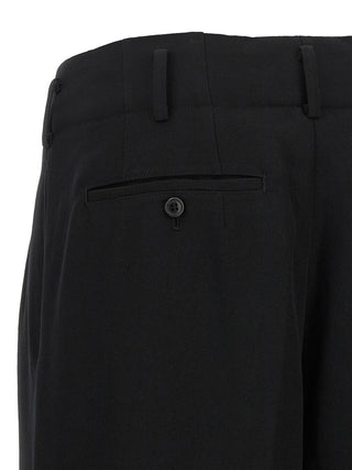 Black wool cropped pants by Comme Des Garçons, tailored fit with a high waist and cropped length, showcased on a model.