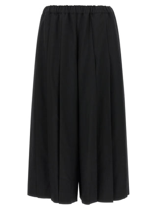 Black wool casual pants by Comme Des Garçons, featuring a relaxed fit and minimalist design, shown on a model.