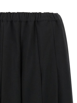 Black wool casual pants by Comme Des Garçons, featuring a relaxed fit and minimalist design, displayed on a neutral background.