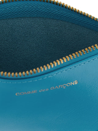 Blue calfskin cardholder by Comme Des Garçons with multiple card slots and sleek minimalist design.