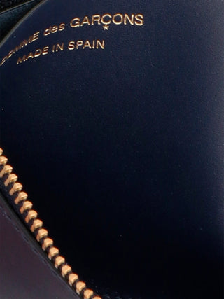 Blue calfskin wallet by Comme Des Garçons featuring a sleek design and minimal stitching, displayed on a neutral background.