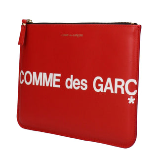 Red leather clutch bag by Comme Des Garçons, showcasing a sleek and stylish accessory with a minimalist design.
