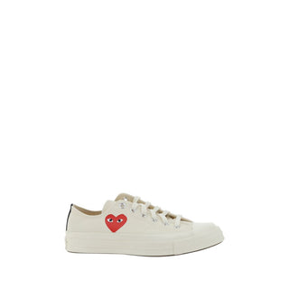 White cotton low top sneakers from Comme Des Garçons Play x Converse, featuring classic casual design and white laces.
