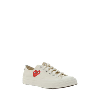 White cotton low top sneakers from Comme Des Garçons Play x Converse, showing classic design and branding details.